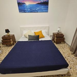 um quarto com uma cama com lençóis e almofadas azuis em TRULLO AURORA BOREALE em Alberobello