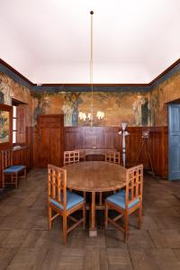una sala da pranzo con tavolo e sedie in legno di Casa Cuseni, Patrimonio Culturale Immateriale UNESCO a Taormina