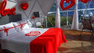 a bedroom with a bed with hearts on the wall at Glamping Campestre Uriyahu in Macanal