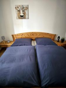 a bedroom with two beds and a cow picture on the wall at Ferienwohnung im schönen Allgäu in Biessenhofen