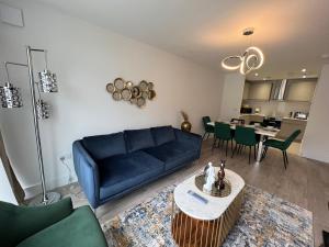 uma sala de estar com um sofá azul e uma mesa em C5, Spacious 3 bedroom flat in Wembley em Londres