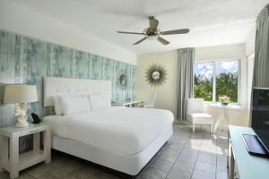 1 dormitorio con cama blanca y ventilador de techo en Beacon South Beach Hotel en Miami Beach