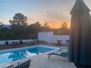 a swimming pool with a sunset in the background at Villa Vittoria in Ghisonaccia