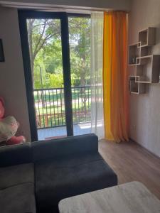 Apartment-M14 in Kikvidze Park في تبليسي: غرفة معيشة مع أريكة ونافذة كبيرة