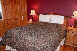 ein Schlafzimmer mit einem Bett und einer lila Wand in der Unterkunft Timber Creek Chalets- 10A chalet in Estes Park