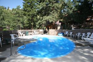 a large blue pool with chairs in a backyard at Timber Creek Chalets- 10A chalet in Estes Park