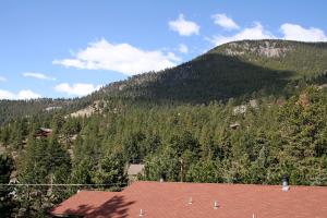 a view of a mountain with a house in the foreground at Timber Creek Chalets- 10A chalet in Estes Park