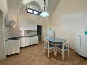 a kitchen with a table and chairs in a room at Casa del Nonno Toto in San Pietro in Lama