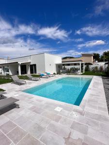 a swimming pool in front of a house at Casa del Sol Luxury Estate Puglia in Leporano Marina