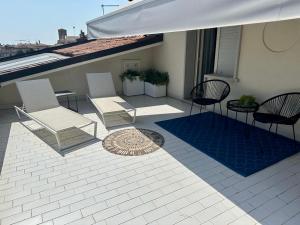 a patio with chairs and an umbrella on a building at JO Hotel in Marano Lagunare