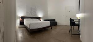 una camera da letto con un letto e una sedia di Domus Delia Luxury Apartment a Napoli