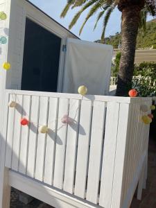 una cerca blanca con fruta en ella delante de una puerta en Lola Casita, en Mijas