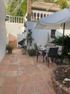 a patio with a table and an umbrella at Lola Casita in Mijas