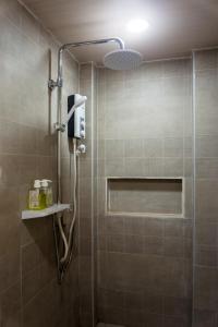 een badkamer met een douche en een glazen deur bij ALONA BEACH SIDE INN in Panglao