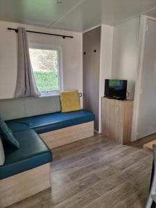 ein Wohnzimmer mit einem Sofa und einem Fenster in der Unterkunft Mobilhome Clim Télé La Falaise 4 étoiles in Narbonne