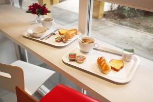 duas bandejas de comida para o pequeno-almoço numa mesa em Premiere Classe St Brieuc Tregueux em Tregueux