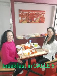 dos mujeres sentadas en una mesa comiendo comida en CALLE 5 - Lima AIRPORT, en Lima