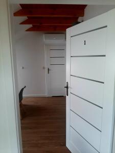 białe drzwi w pokoju z korytarzem w obiekcie Pensjonat Kaprys w Solcu-Zdroju