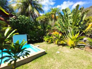 a garden with a swimming pool in the grass at Moorea Pool & Lagoon House in Moorea