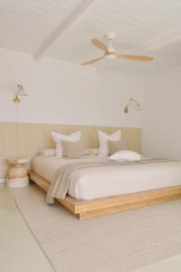 a white bedroom with a large bed with white pillows at Casa MareTerra - Design Villa with Pool and Terrace near Corralejo and Lajares in Corralejo