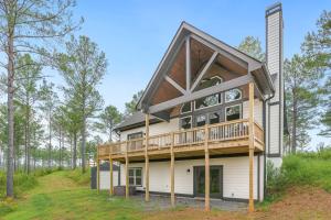 a house with a wrap around deck on a hill at High River Homestays in East Ellijay