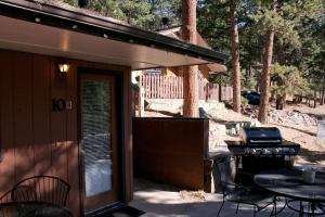 a patio with a grill and a table and chairs at Timber Creek Chalets- 10B chalet in Estes Park