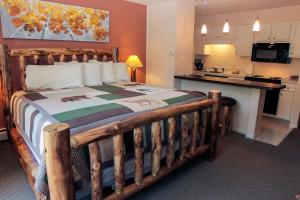 a bedroom with a wooden bed and a kitchen at Fawn Valley Inn- 278 condo in Estes Park