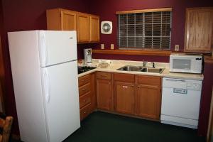 a kitchen with a white refrigerator and a sink at Timber Creek Chalets- 12 chalet in Estes Park