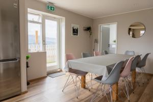 eine Küche und ein Esszimmer mit einem Tisch und Stühlen in der Unterkunft Big house with a view in Akureyri