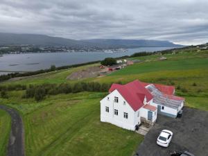 una casa blanca con techo rojo en un campo verde en Big house with a view, en Akureyri