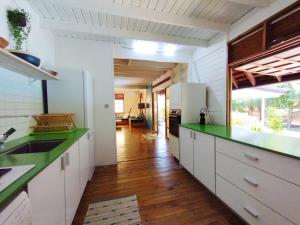 a kitchen with white cabinets and green counter tops at Moorea Pool & Lagoon House in Moorea