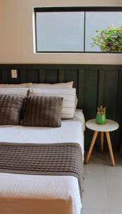 a bedroom with a large bed and a table at Studio Bougainville - Praia do Rosa in Imbituba