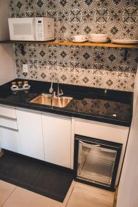 a kitchen with a sink and a stove at Studio Bougainville - Praia do Rosa in Imbituba