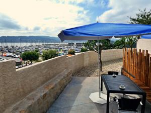 einen Tisch mit einem blauen Regenschirm auf dem Balkon in der Unterkunft Apartamentos Dabarca Combarro in Combarro