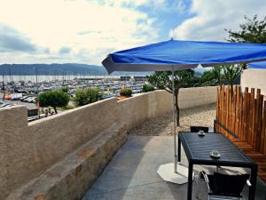 a table with a blue umbrella on a balcony at Apartamentos Dabarca Combarro in Combarro
