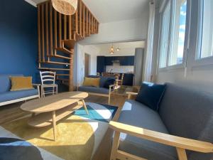 a living room with a couch and a table at joli duplex centre ville 5 min à pied de la gare sncf in La Loupe