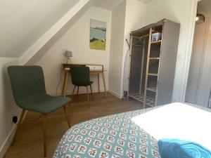 a bedroom with a bed and a desk and chairs at joli duplex centre ville 5 min à pied de la gare sncf in La Loupe