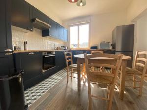 a kitchen with a table and chairs in a room at joli duplex centre ville 5 min à pied de la gare sncf in La Loupe