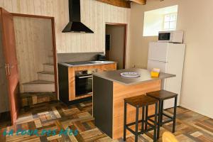 a kitchen with a refrigerator and a counter with stools at Appartement La Roche-Bernard - Plein centre - 50m² in La Roche-Bernard