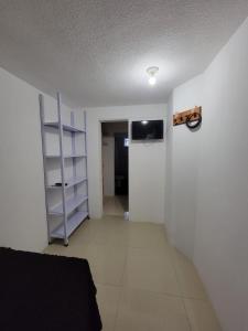 an empty room with a tv on a white wall at (2) cuarto maravilloso para descansar y asearse in Tlazcalancingo