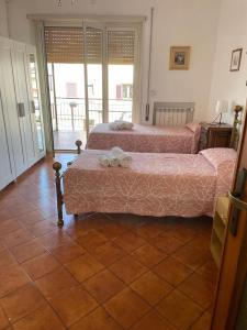 Habitación con 2 camas y suelo de baldosa. en Casa Roncaccia, en Grottaferrata