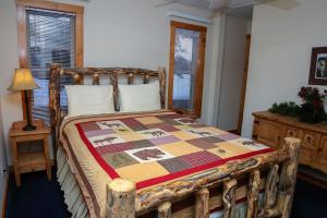 a bedroom with a wooden bed with a quilt on it at Timber Creek Chalets- 9 chalet in Estes Park