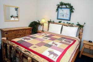 a bedroom with a bed with a quilt on it at Timber Creek Chalets- 9 chalet in Estes Park