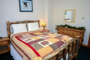 a bedroom with a bed with a quilt on it at Timber Creek Chalets- 9 chalet in Estes Park