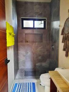 uma casa de banho com um chuveiro, um WC e uma janela. em Chic PH Private Pool/Rooftop near to beachfront em Tulum