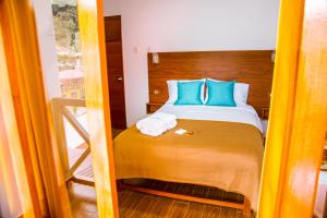 um quarto com uma cama com almofadas azuis em La Posada D'Benjamín em Oxapampa