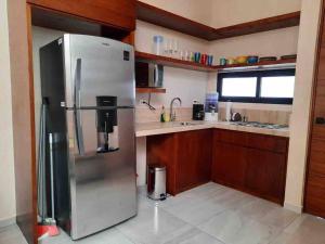 uma cozinha com um grande frigorífico de aço inoxidável em Chic PH Private Pool/Rooftop near to beachfront em Tulum