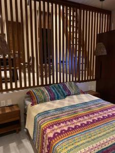 um quarto com uma cama e uma parede de madeira em Chic PH Private Pool/Rooftop near to beachfront em Tulum
