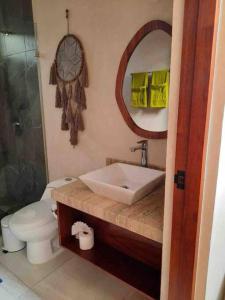 uma casa de banho com um lavatório, um WC e um espelho. em Chic PH Private Pool/Rooftop near to beachfront em Tulum