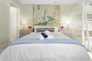 een witte slaapkamer met een bed met 2 stapelbedden bij Your Modern Family Retreat, Sleeps 10! in Durham